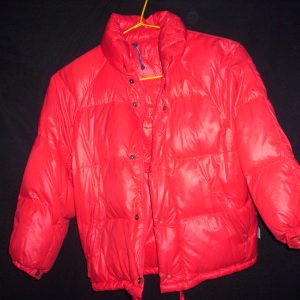 A heavy red insulated down parka hanging on a hanger, showing full puffy baffle construction
