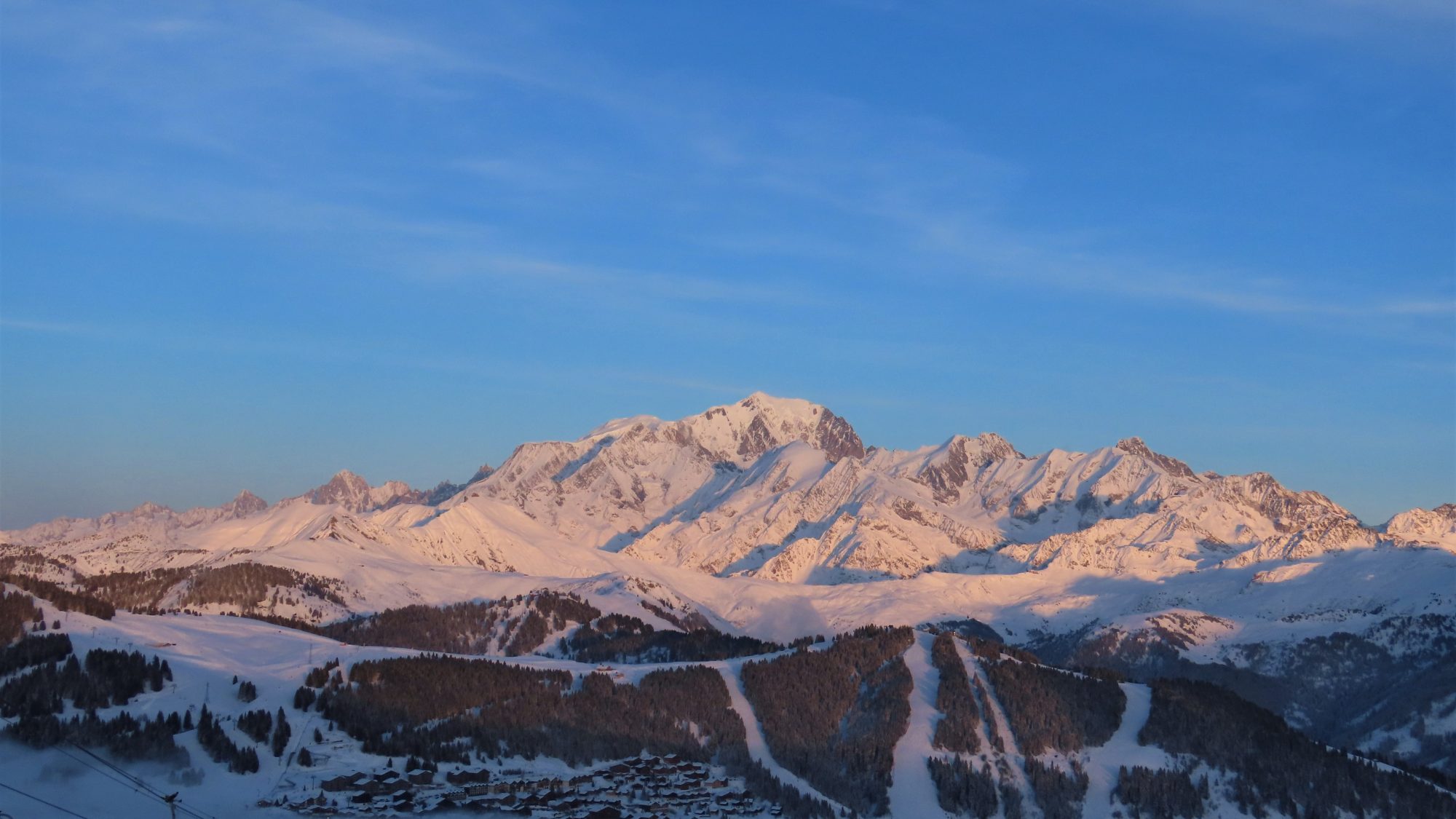 The snow-covered Mont Blanc massif glowing at golden hour above the Savoie valley, viewed from Signal de Bisanne, France