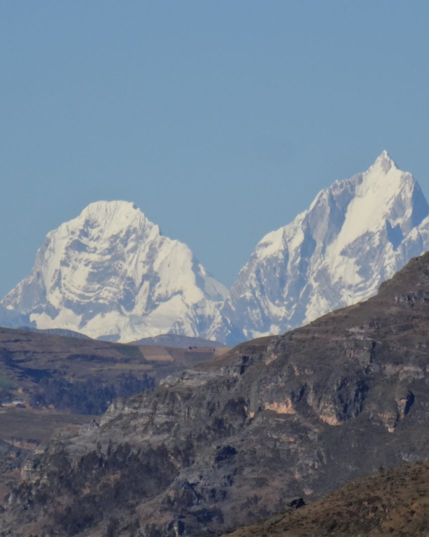 Snow-covered peaks of Siula Grande and Yerupaja rising above the Andean foothills, Cordillera Huayhuash, Peru