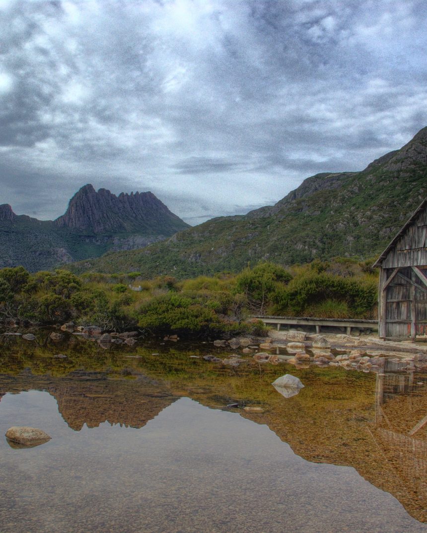 Cradle Mountain's jagged peaks reflected in Dove Lake with the historic wooden boat shed, Tasmania, Australia